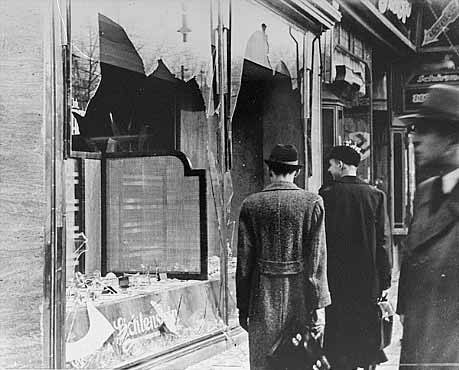 Germans pass broken window of Jewish-owned shop